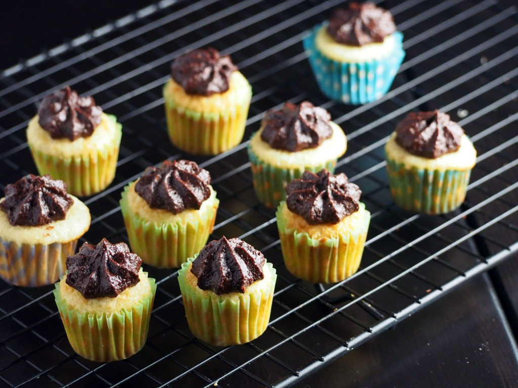 Enjoy these mini vanilla cupcakes that is mildly sweet with a creamy, decadent cocoa frosting.