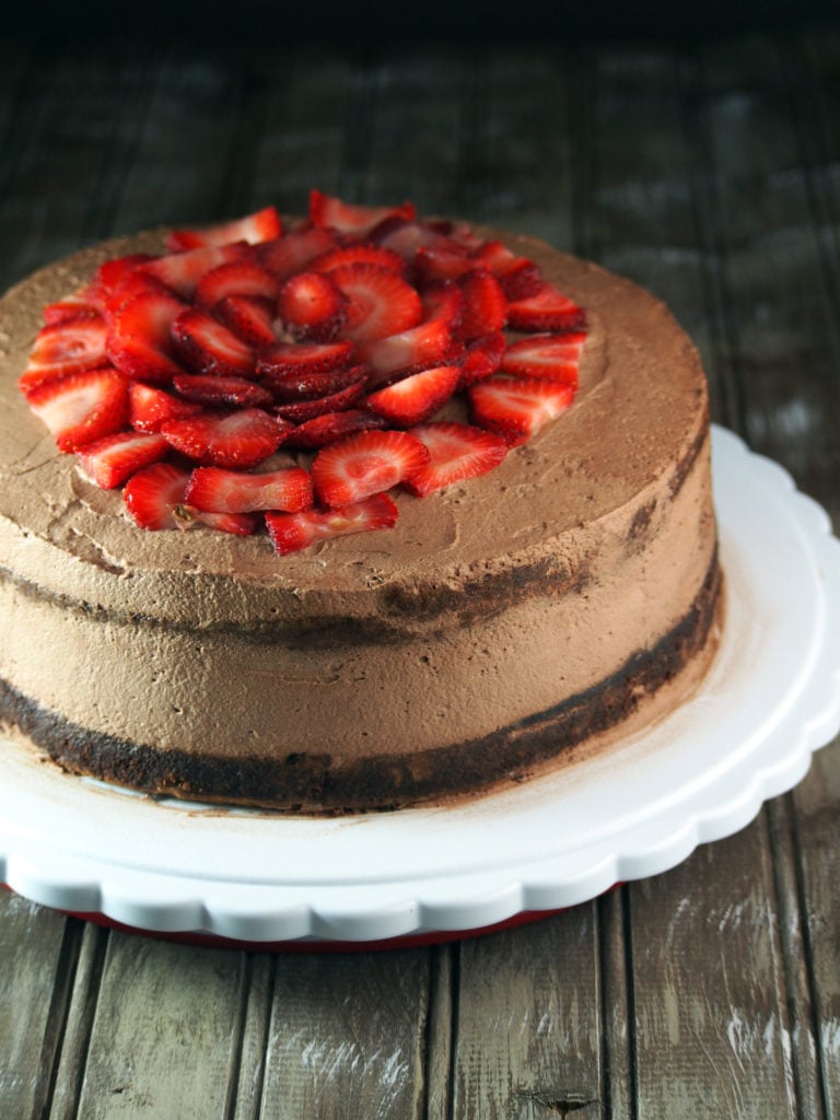 Chocolate cake topped with fresh strawberry slices.