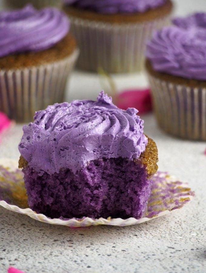 Ube cupcake with a bite, showing the inside crumb of cake.