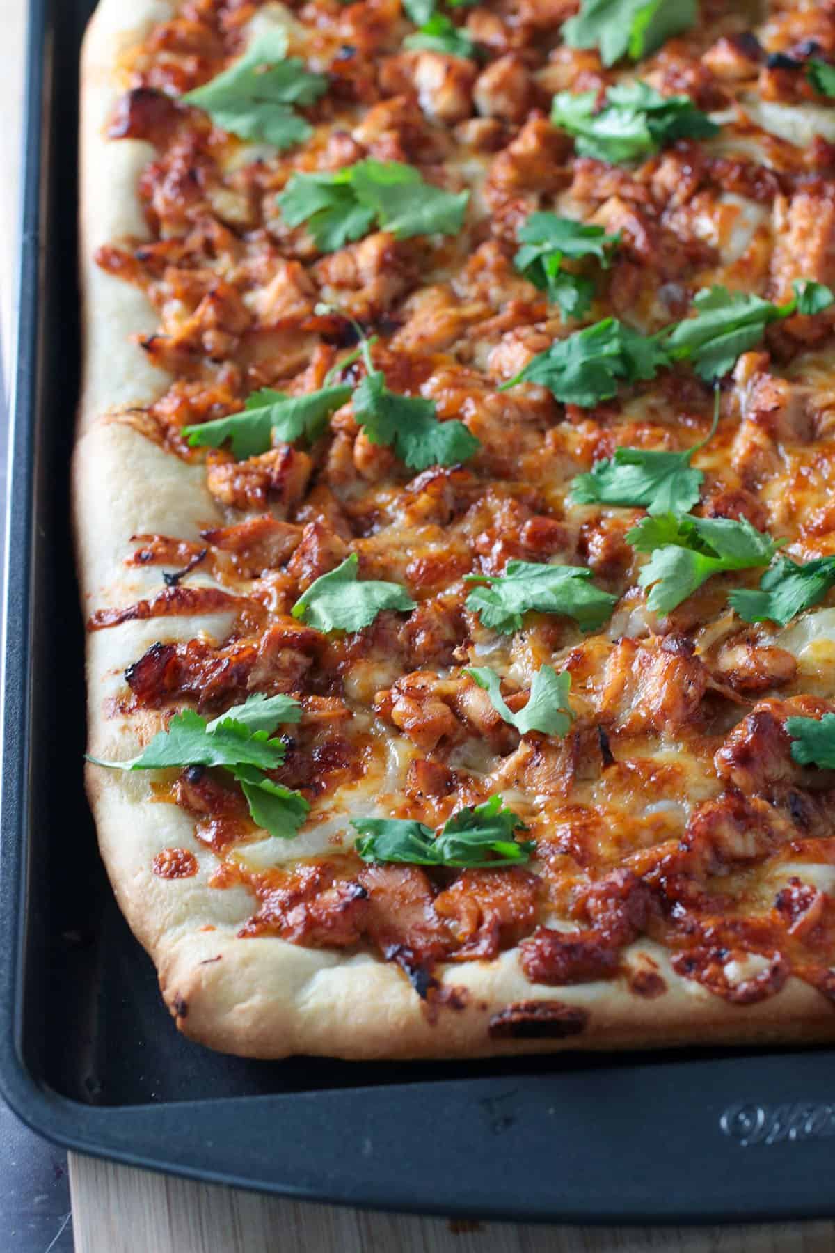 Chicken BBQ pizza on a baking pan.