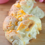 Soft cheddar cheese bread that is packed with cheddar cheese on top and sprinkled with sugar