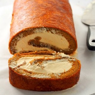 Photo of coffee swiss roll with one cut slice.