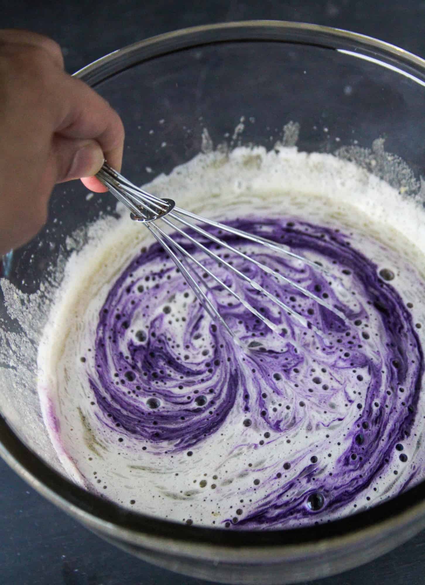 Mixing in the ube flavoring onto the yolk mixture.