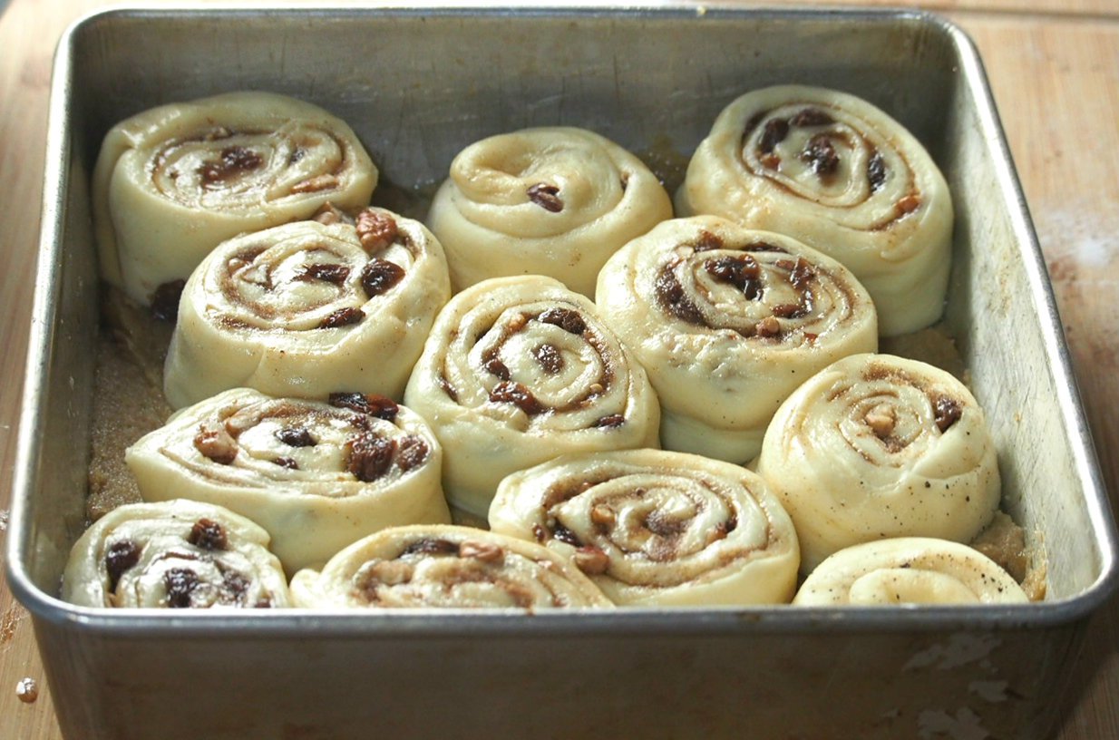 These sticky buns are loaded with pecan nuts and raisins, and covered in a sweet and sticky brown sugar topping. These are the ultimate cinnamon rolls using brioche dough that is packed with  flavorful cinnamon sugar filling.