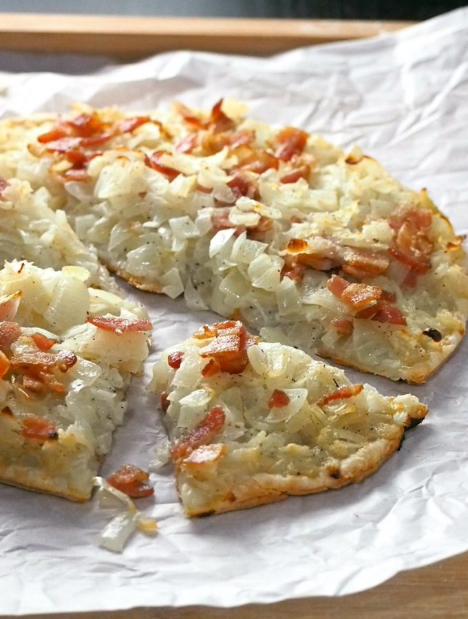 This Onion Tart is a tasty appetizer made with soft, juicy onions piled together with bits of bacon on a crisp and light puff pastry crust.