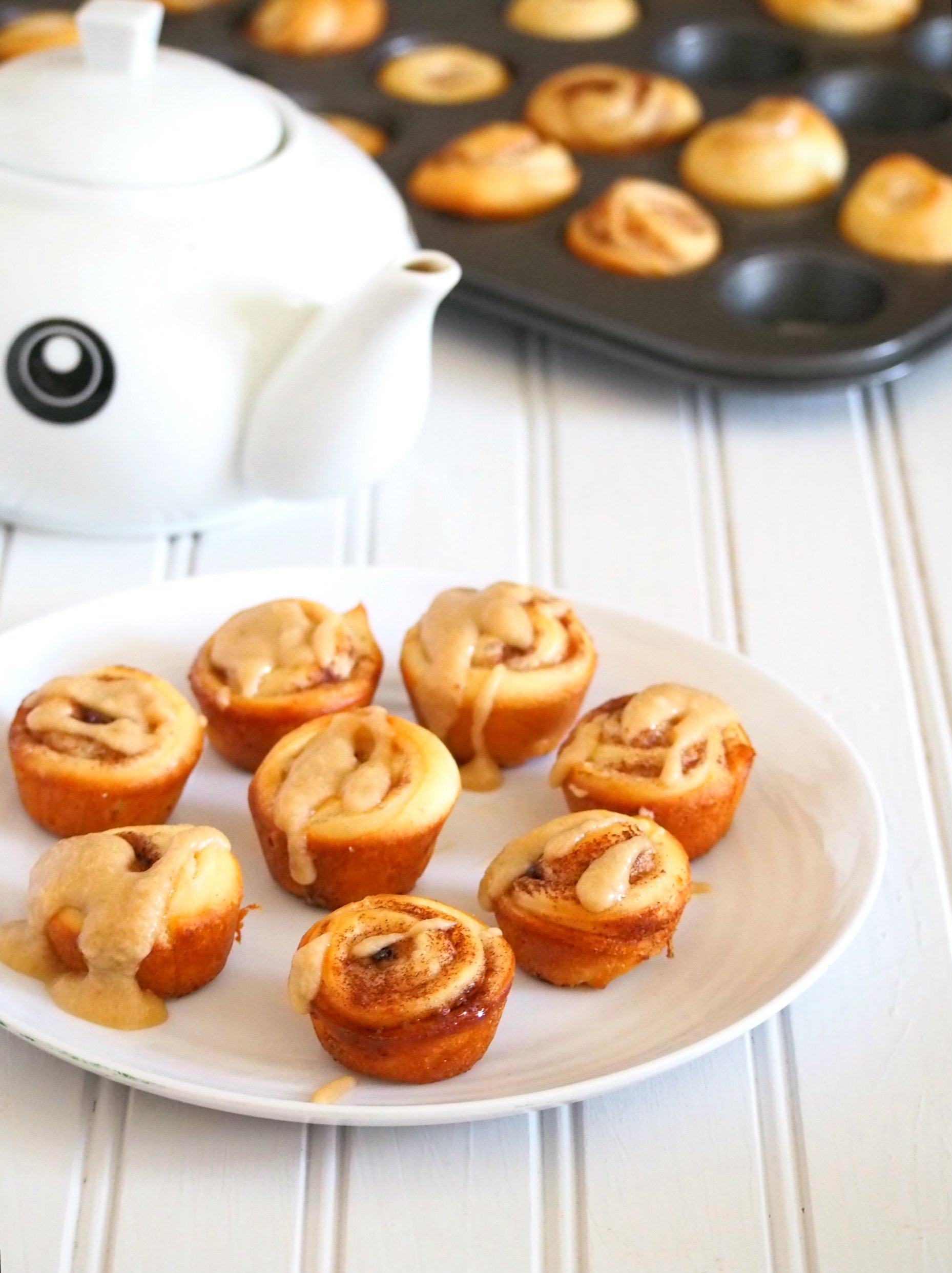 Photo of mini cinnamon rolls glazed with creamy coffee icing in a plate.