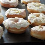 Soft, airy and light yeast donuts are delicious treats especially when glazed with luscious white chocolate and topped with crunchy almond slices.