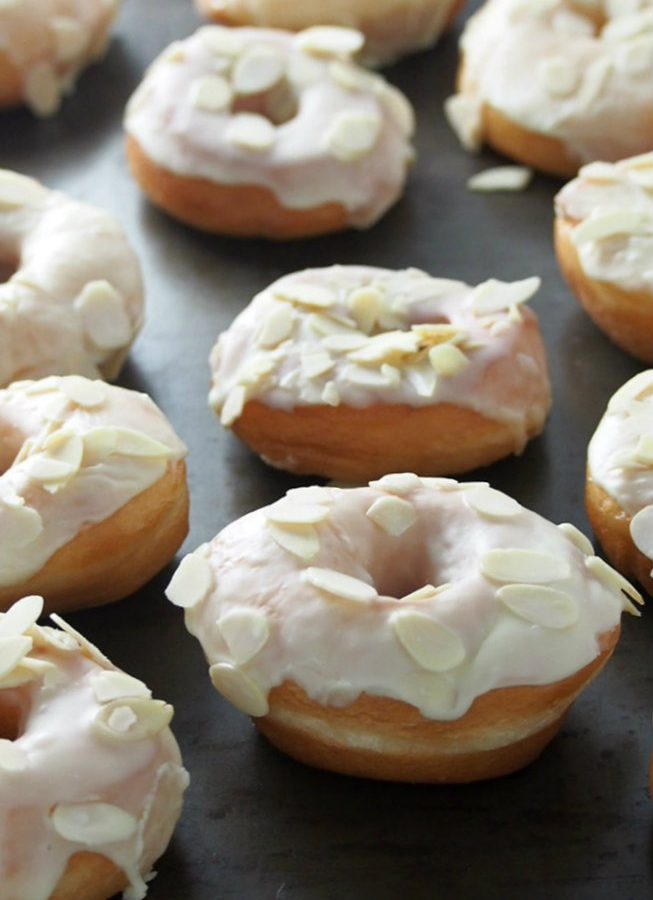 Soft, airy and light yeast donuts are delicious treats especially when glazed with luscious white chocolate and topped with crunchy almond slices.