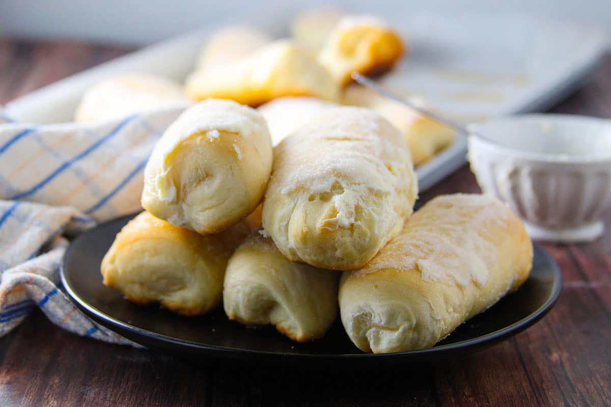 Sweet cheese rolls stacked on a plate.