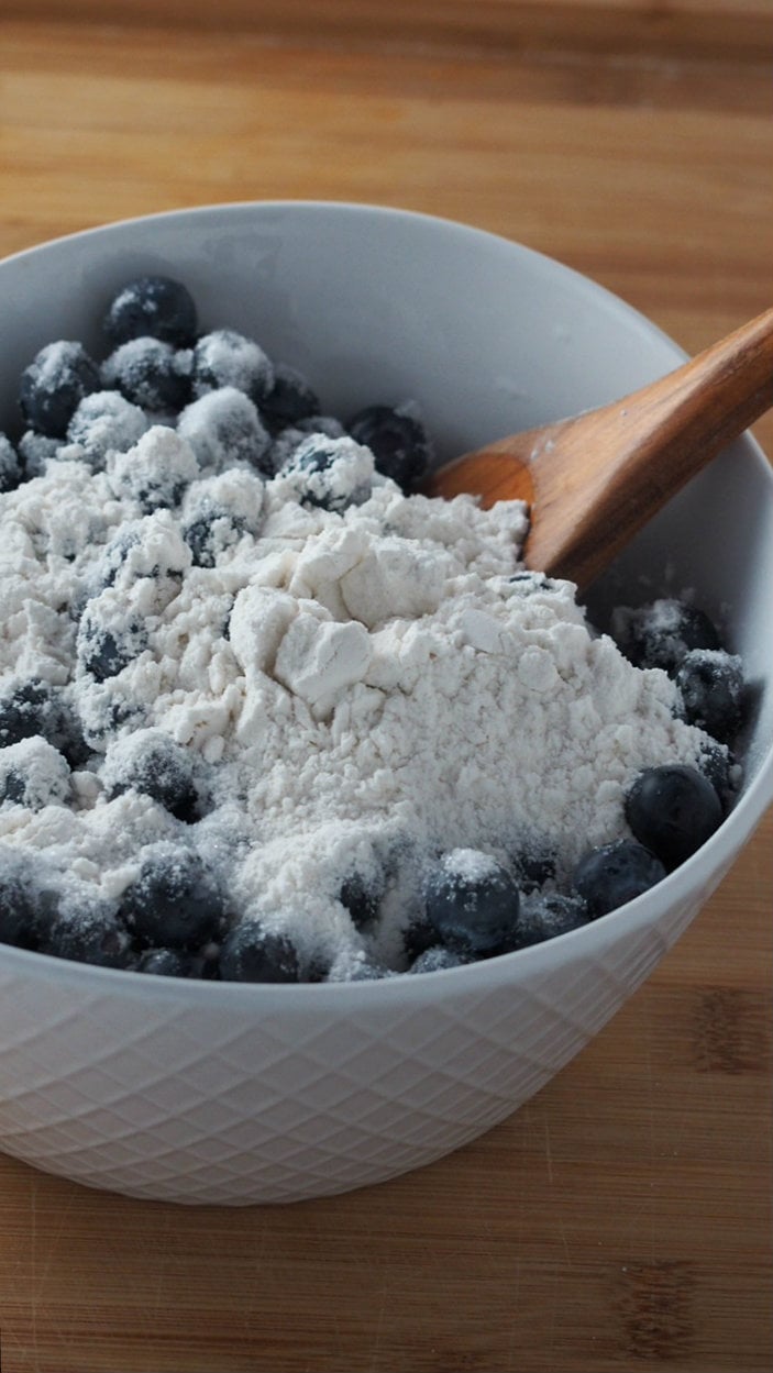 Coating the fresh blueberries with flour.