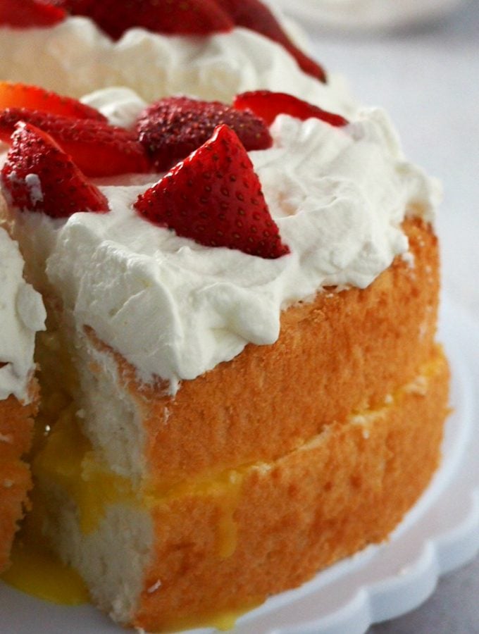 Enjoy this Lemon Angel Food Cake with Lemon Curd Filling- the cottony soft angel food cake is filled with a splash of bright flavor from the lemon curd, then finished with a whipped cream topping.