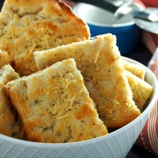 Focaccia bread sliced into rectangles and arranged in a bowl.