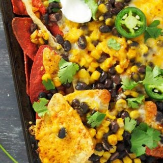 A warm, freshly baked sheet pan bean and corn nachos ready for digging in.
