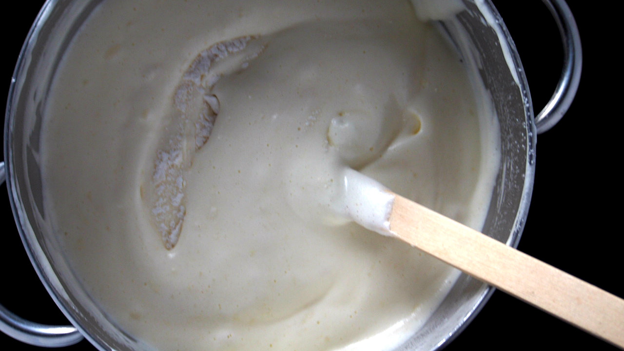 The flour mixture is being mixed into the egg batter to make the final batter for Boston Cream Pie.