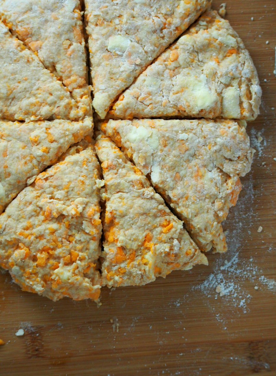The dough of sweet potato scones haped into a disc and cut into 8 wedges.