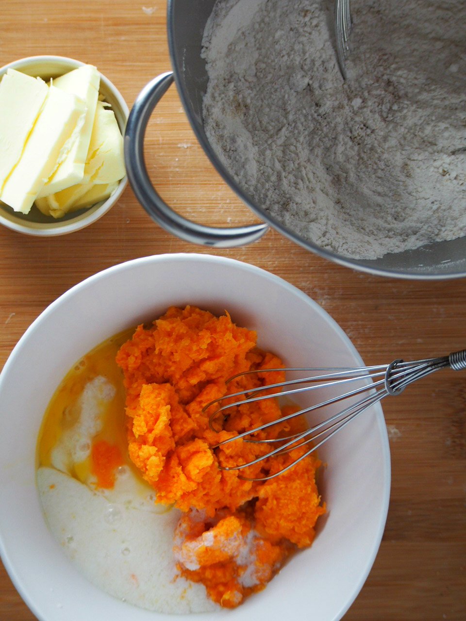 Ingredients of sweet potato scones are ready to be mixed into a dough : mashed sweet potato and buttermilk, flour mixture and butter.