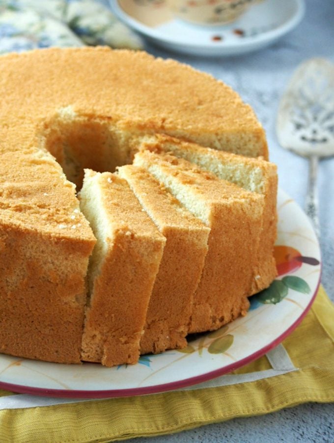 Vanilla Chiffon Cake on a serving plate with some part sliced.