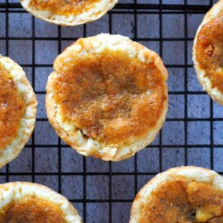 Close up view of a butter tart on a cooling rack.