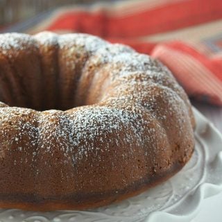 Banana Bundt cake on a cake server dusted with icing sugar.