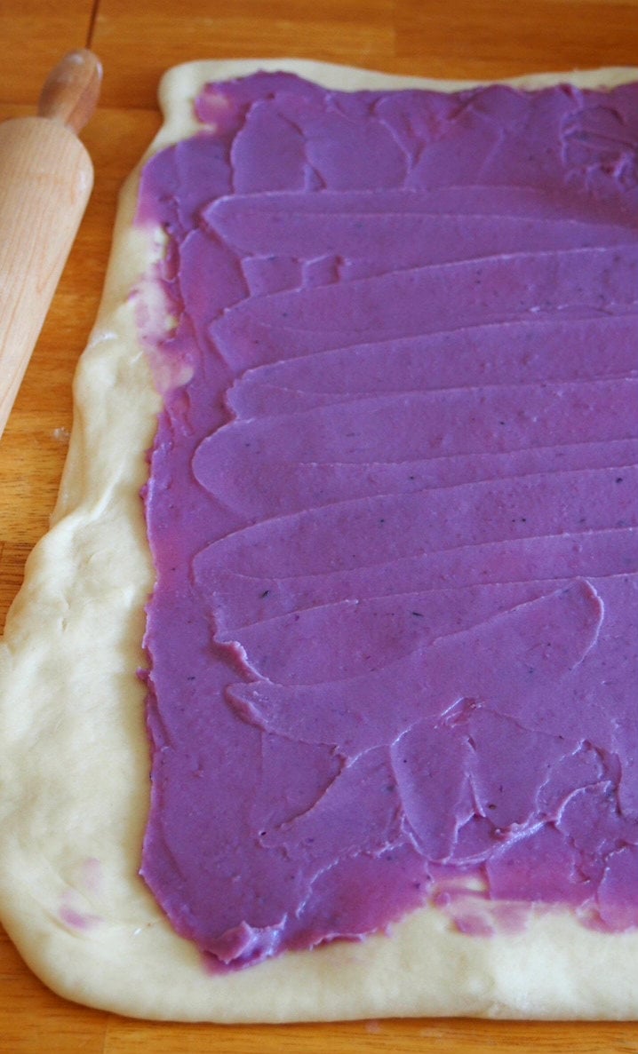 The ube jam spread on the rolled rectangular dough.