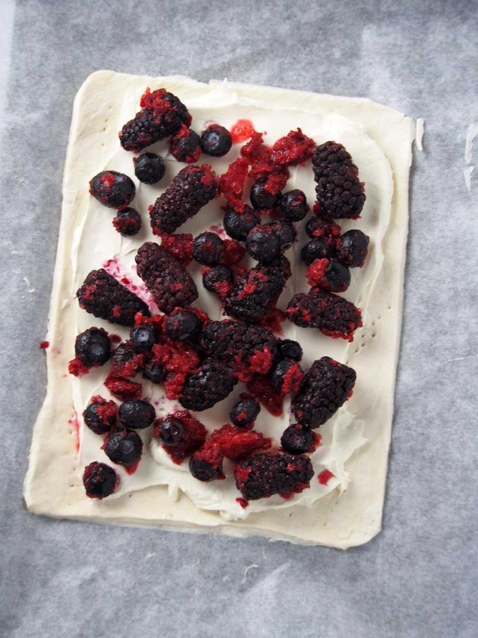 Cream cheese mixture spread all over the puff pastry, leaving a border, then the berries are arranged on top.