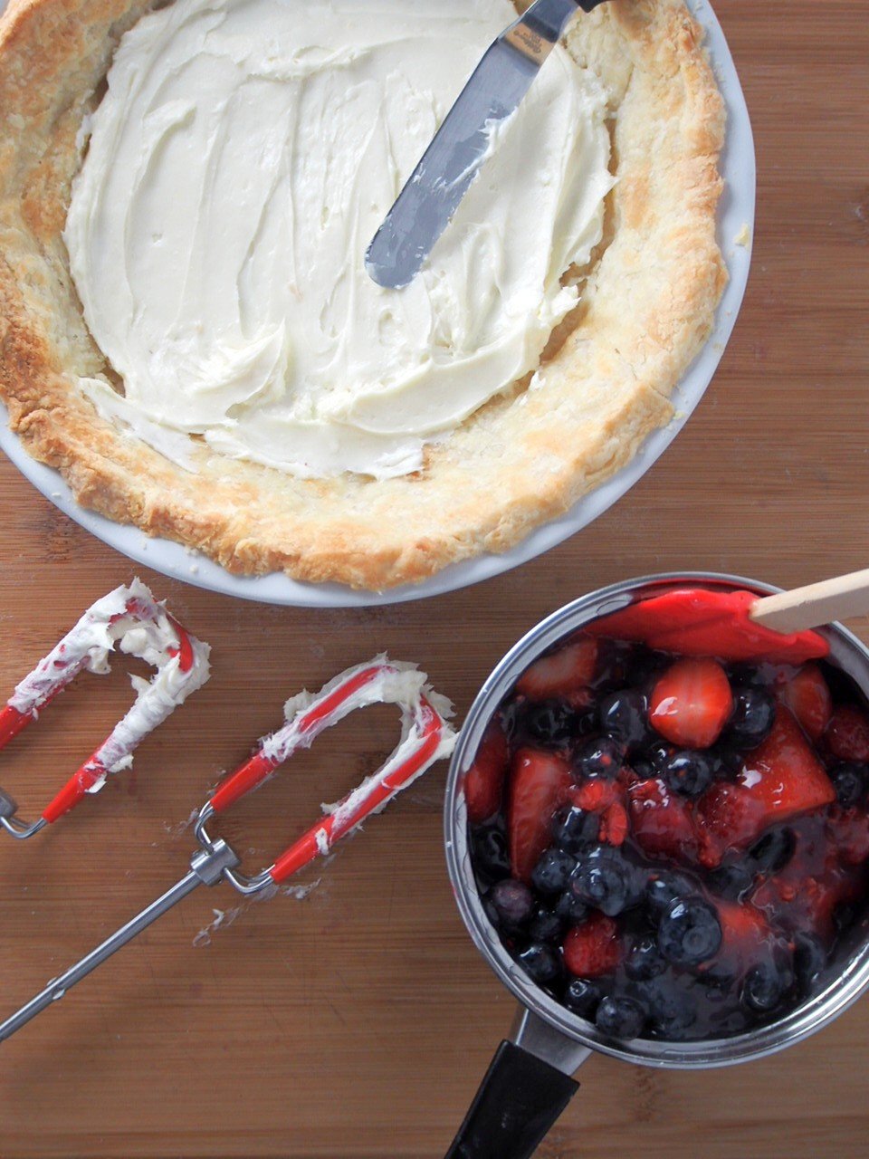 Spreading the cream cheese filling into the pie crust.