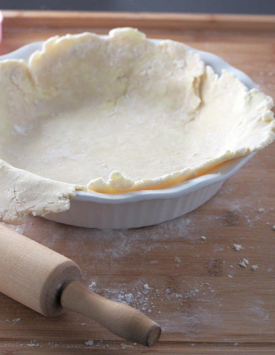 Placing the pie crust into the pie pan.