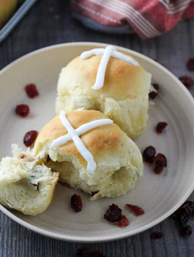 Two pieces of hot cross buns on a plate.