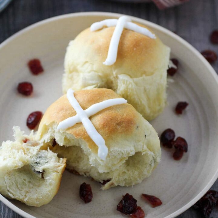 Two pieces of hot cross buns on a plate.
