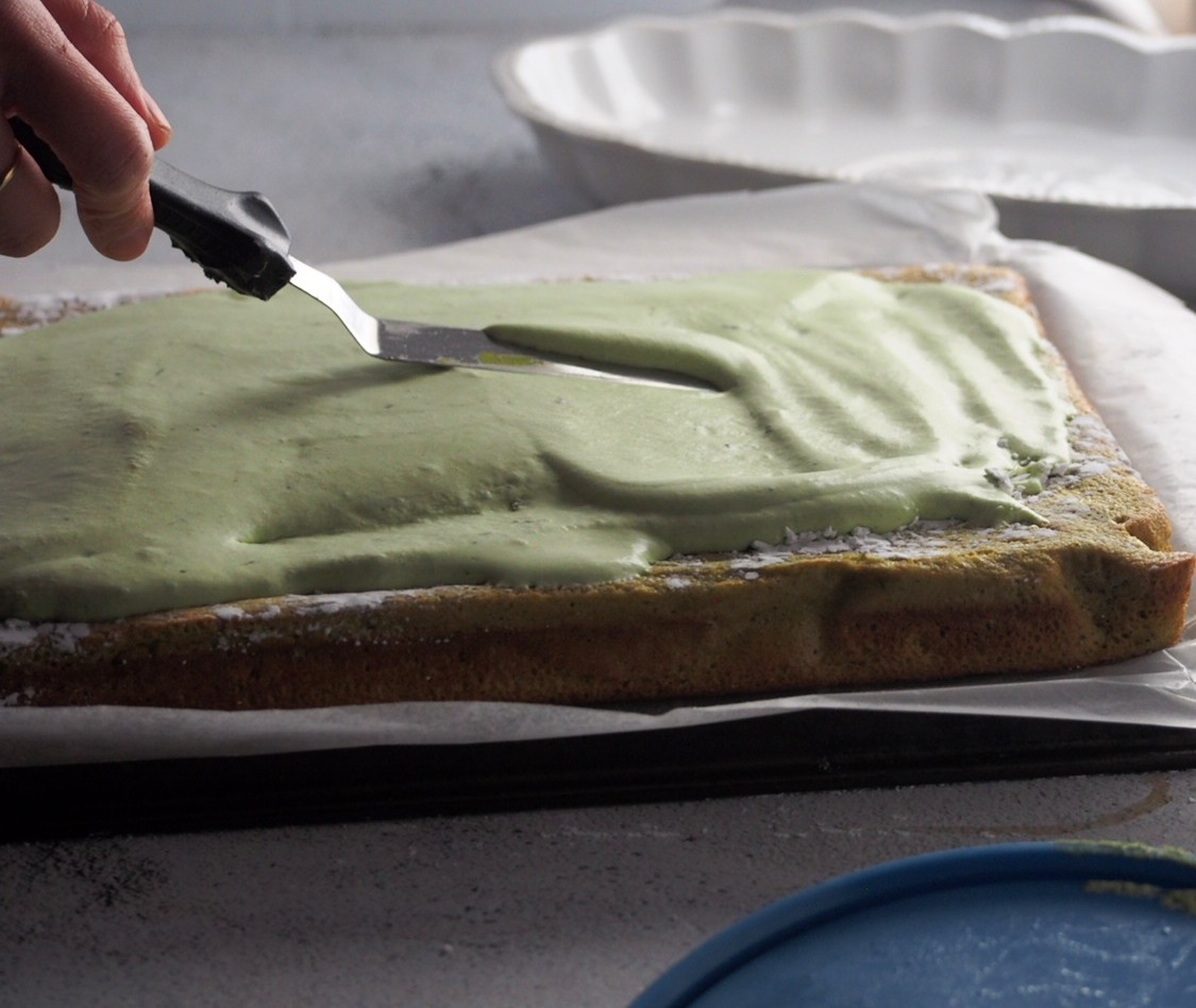 Spreading the whipped cream on the matcha chiffon.