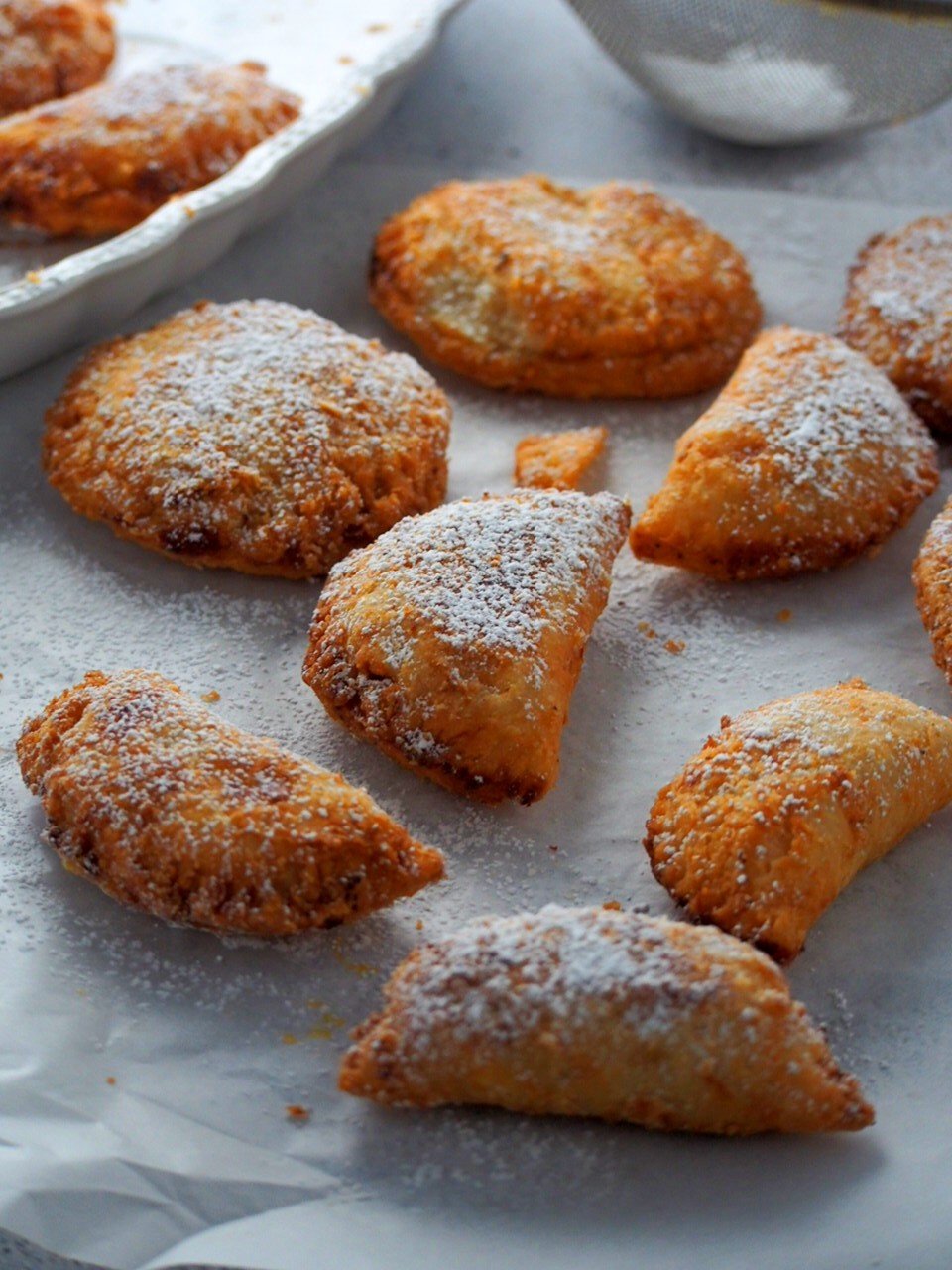 Peach Mango pies freshly fried and dusted with powdered sugar.