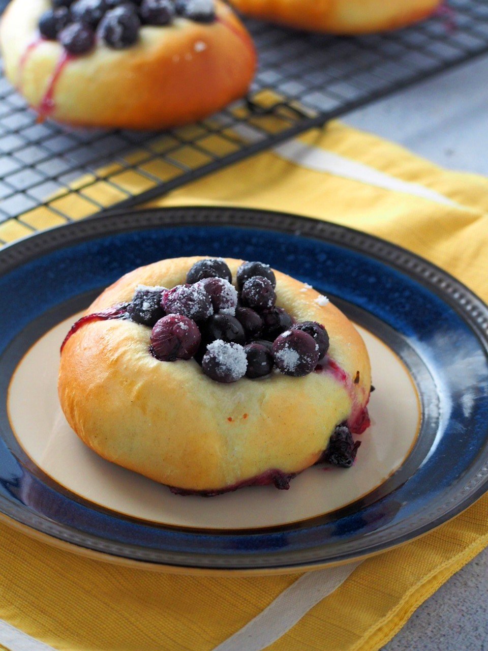 A blueberry bun served on a plate.