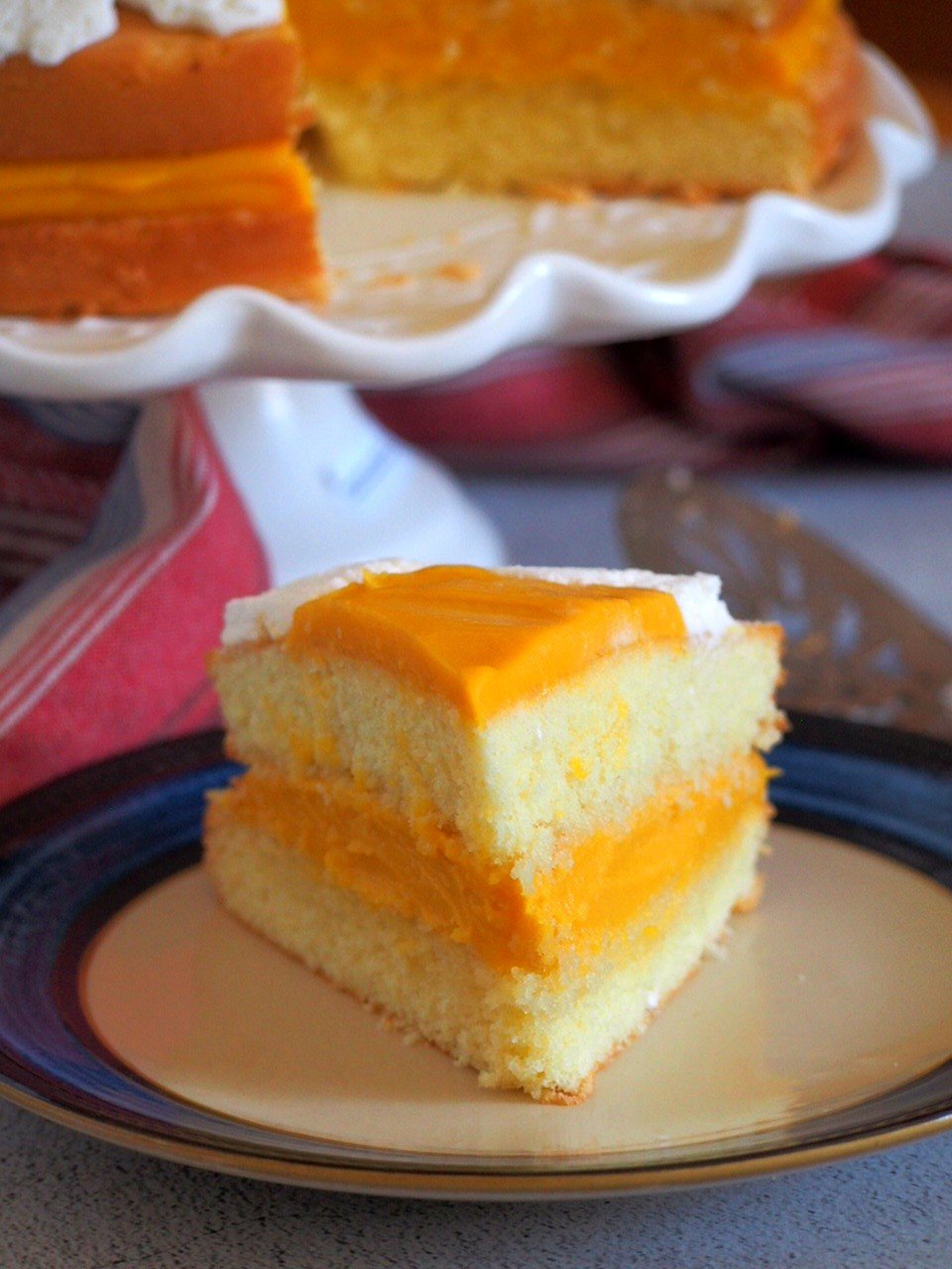 One slice of mango cream cake on a plate.