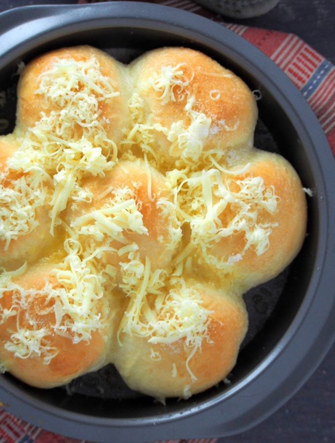 Pan de Siosa is all topped with cheese, butter and sugar in the baking pan.