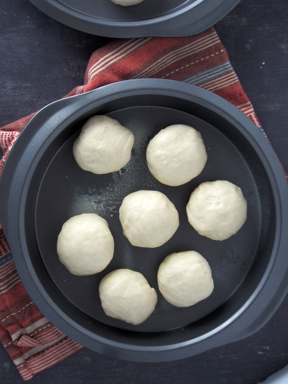 Pan de siosa dough shaped into smooth balls on a baking pan.