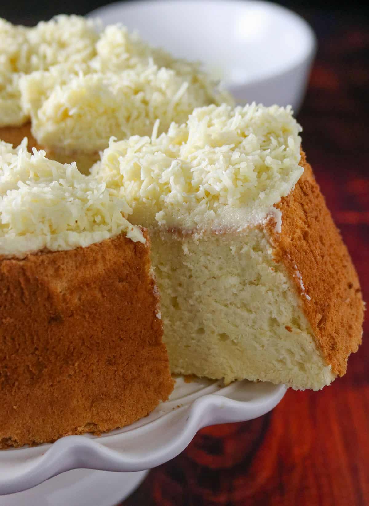 Close up of a sliced cheese chiffon cake on a cake stand.