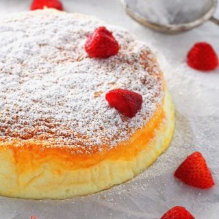 Condensed Milk Cheesecake garnished with icing sugar and strawberries.