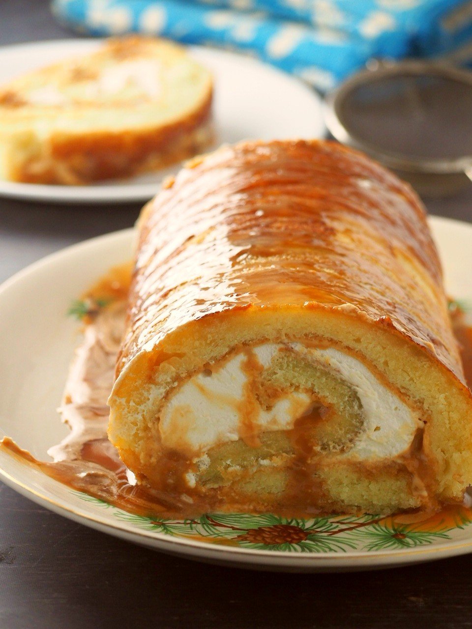 dulce de leche cake roll photo with one slice at the background.