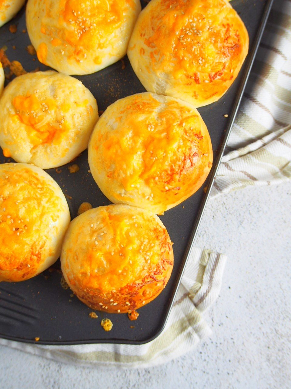 Top angle shot of cheddar cheese buns on a muffin pan.