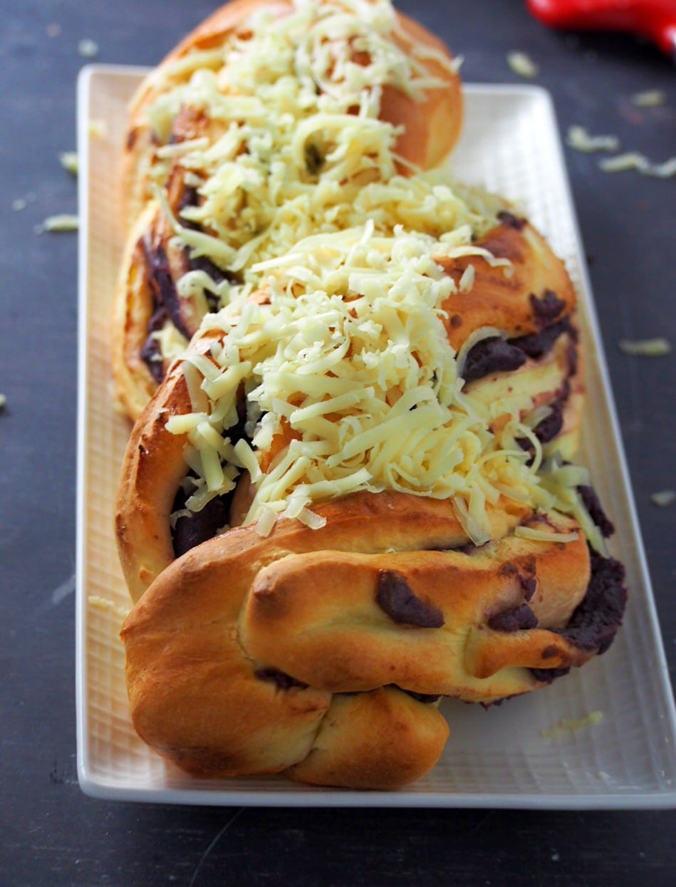 An ube ensaymada braid topped with grated cheese.