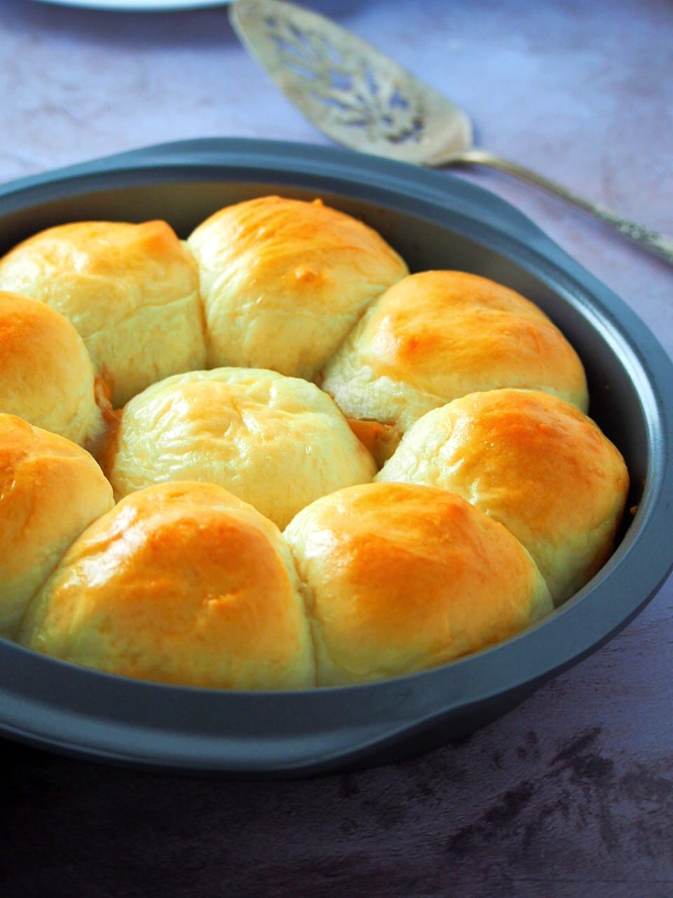Dulce de leche bread rolls on a round pan.