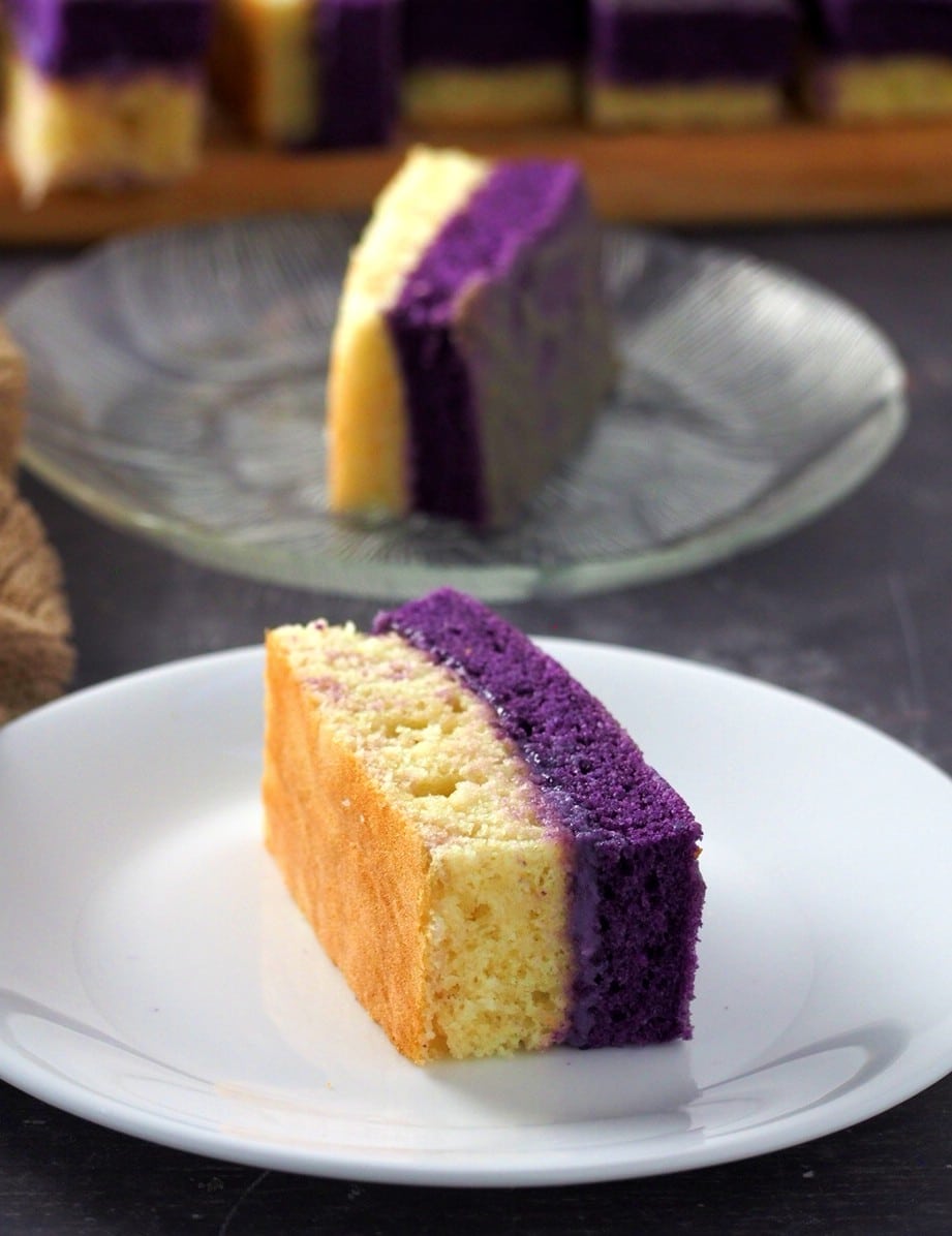 One Ube and vanilla cake slice on each of their serving plates.
