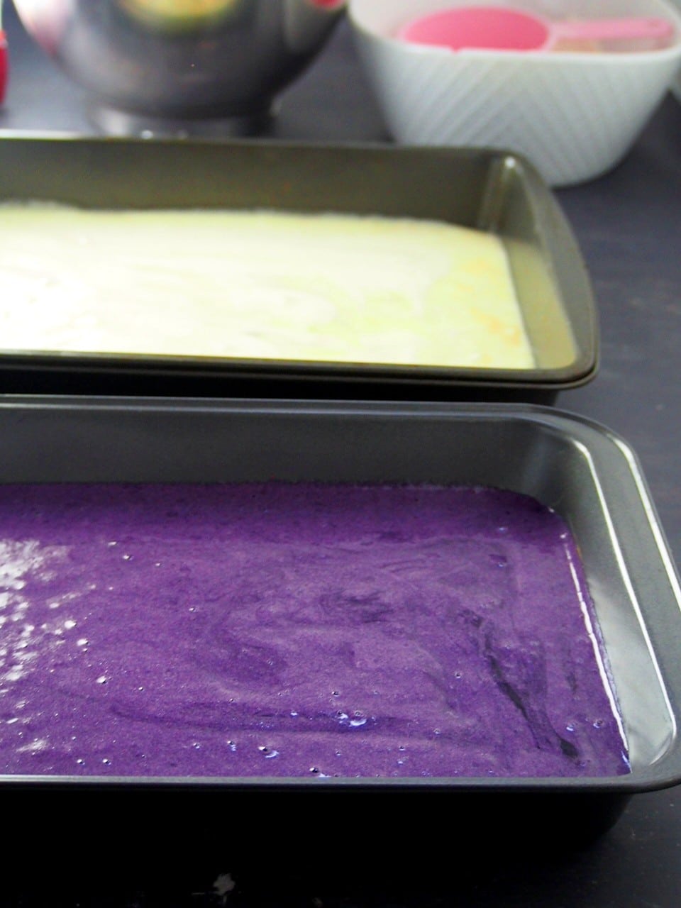The ube and vanilla cake batters on baking pans ready for baking.