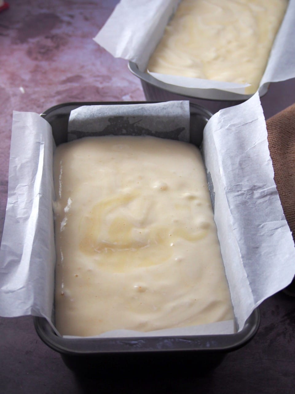 Taisan cake batters in 2 loaf pans, ready for baking.