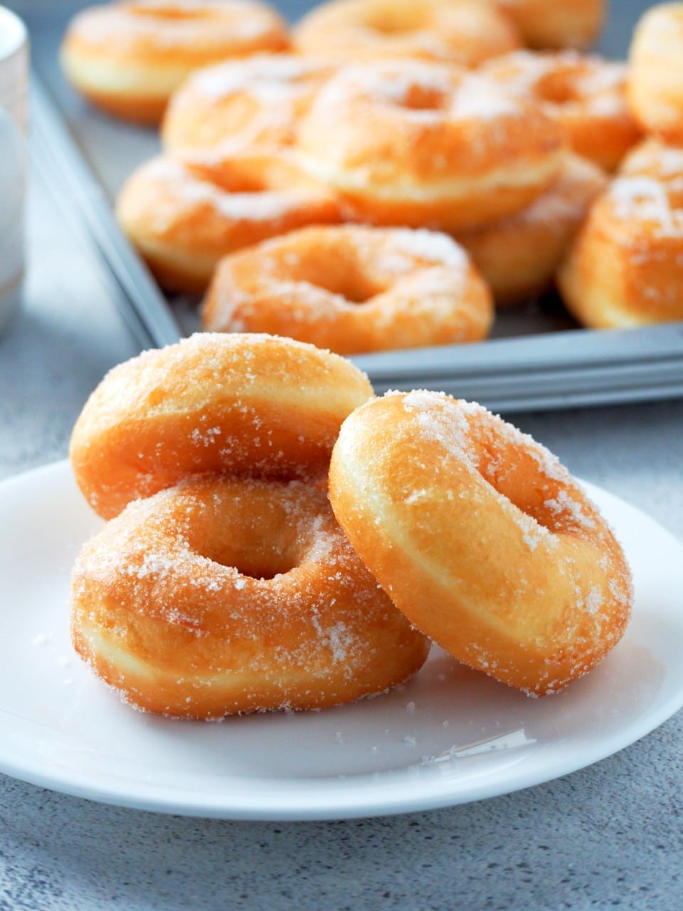 Donuts rolled in sugar on a serving plate.