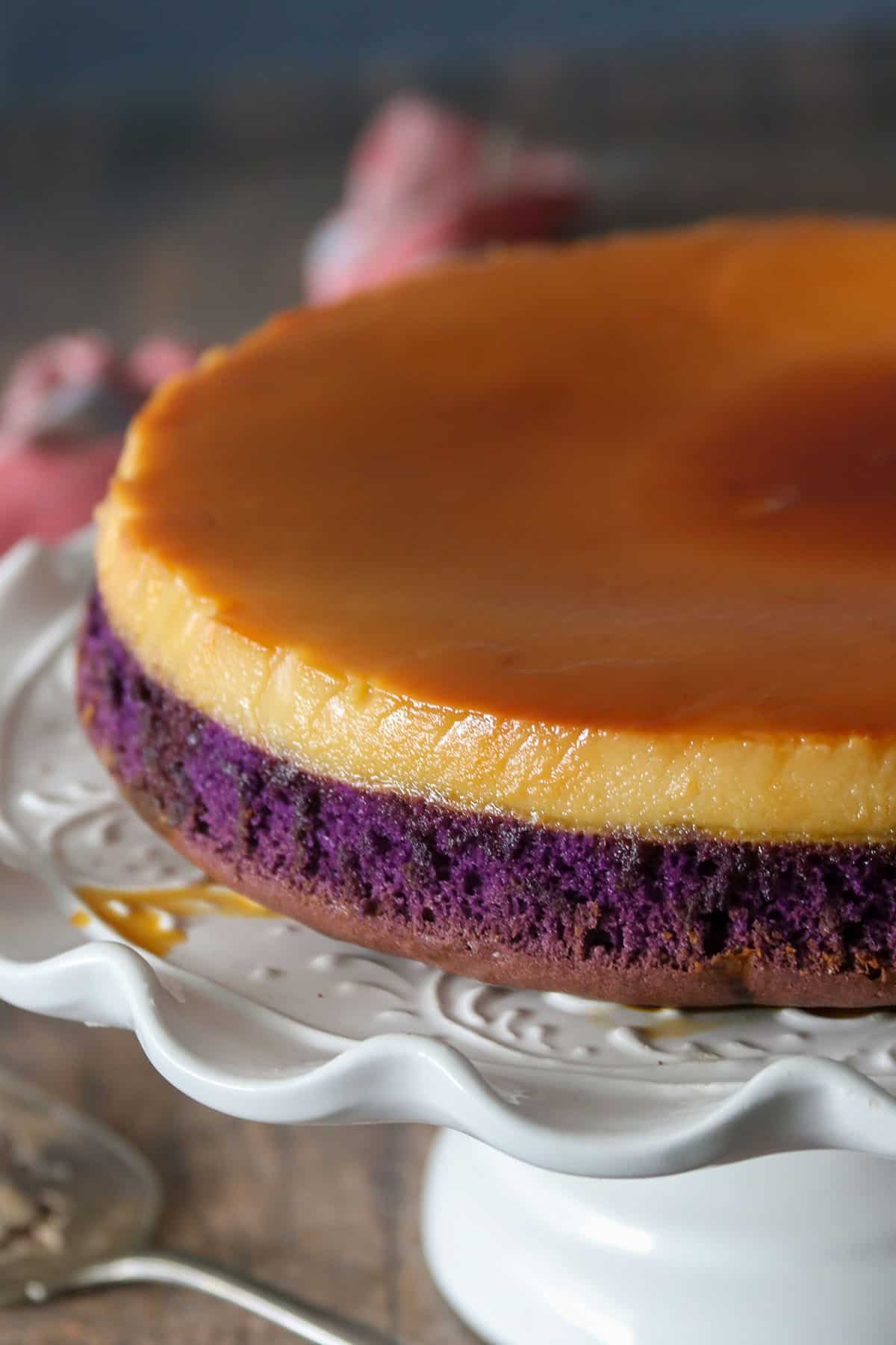The whole ube flan cake on a cake stand.