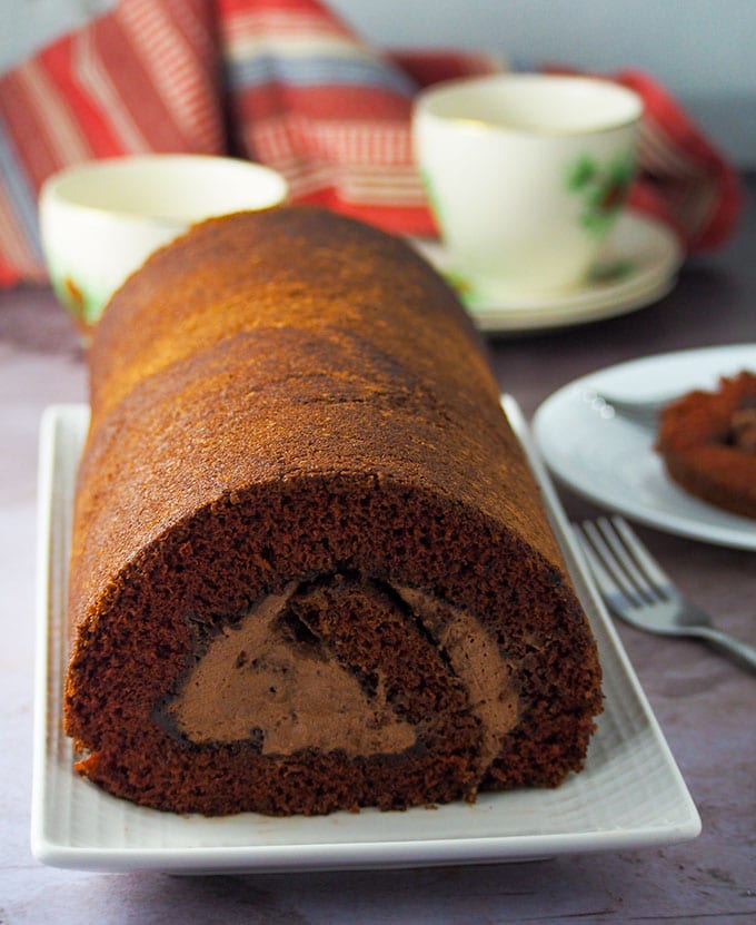 Whole shot of chocolate cake roll in a serving plate.