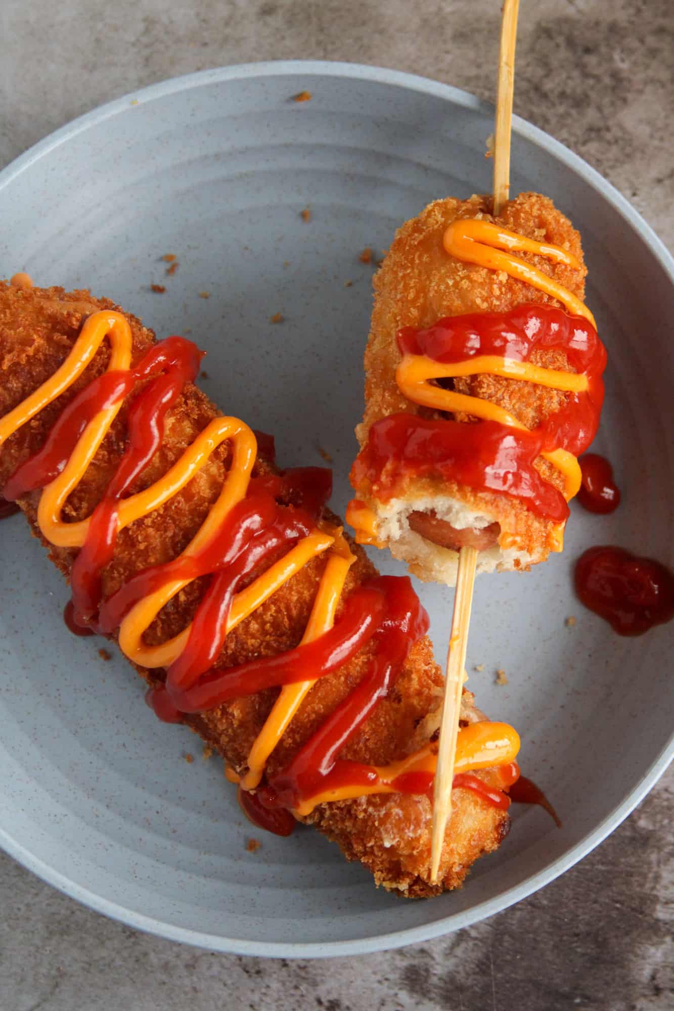 Top shot of two Korean corn dogs on a plate.