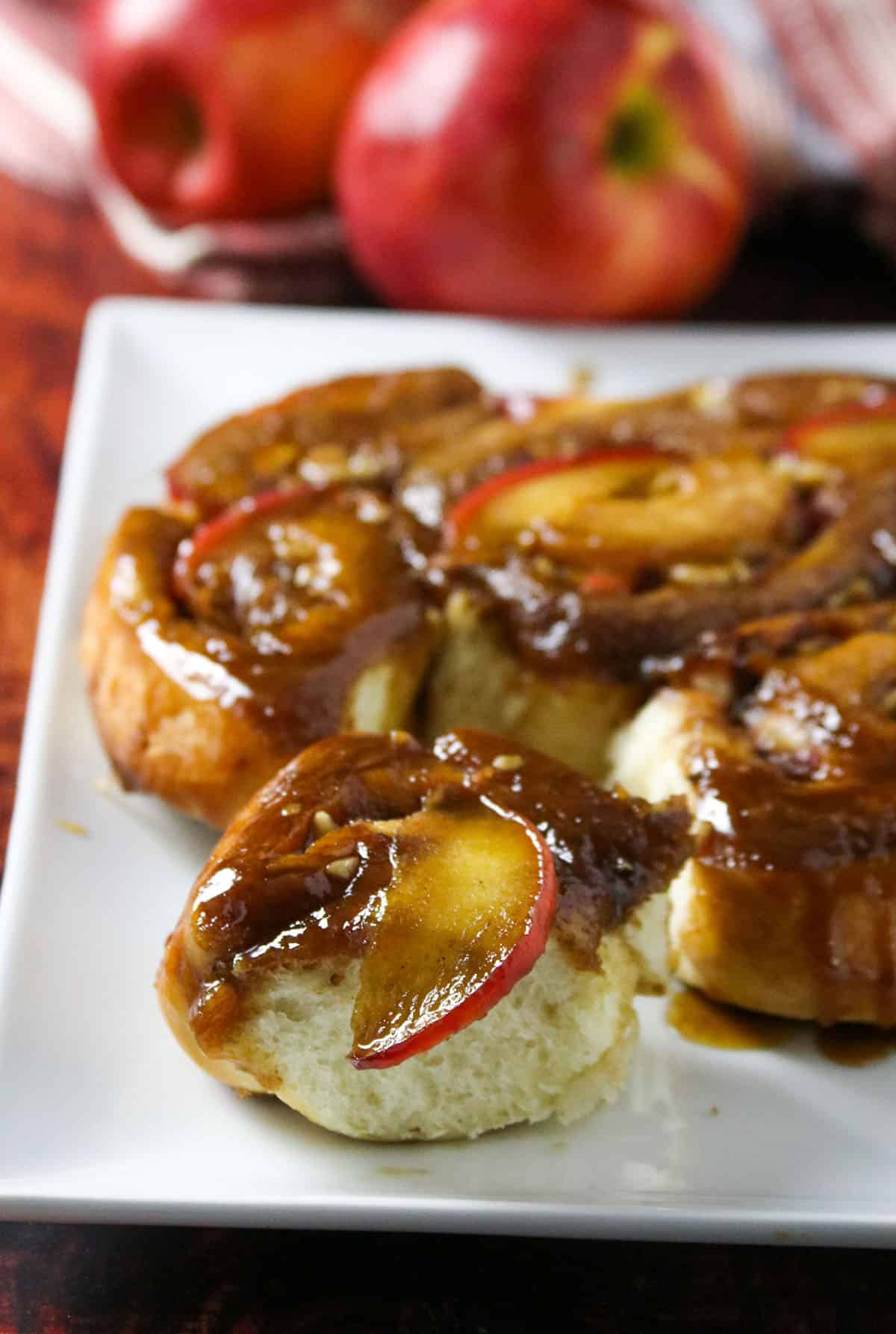 Close up shot of an apple sticky buns with caramelized apples on top.
