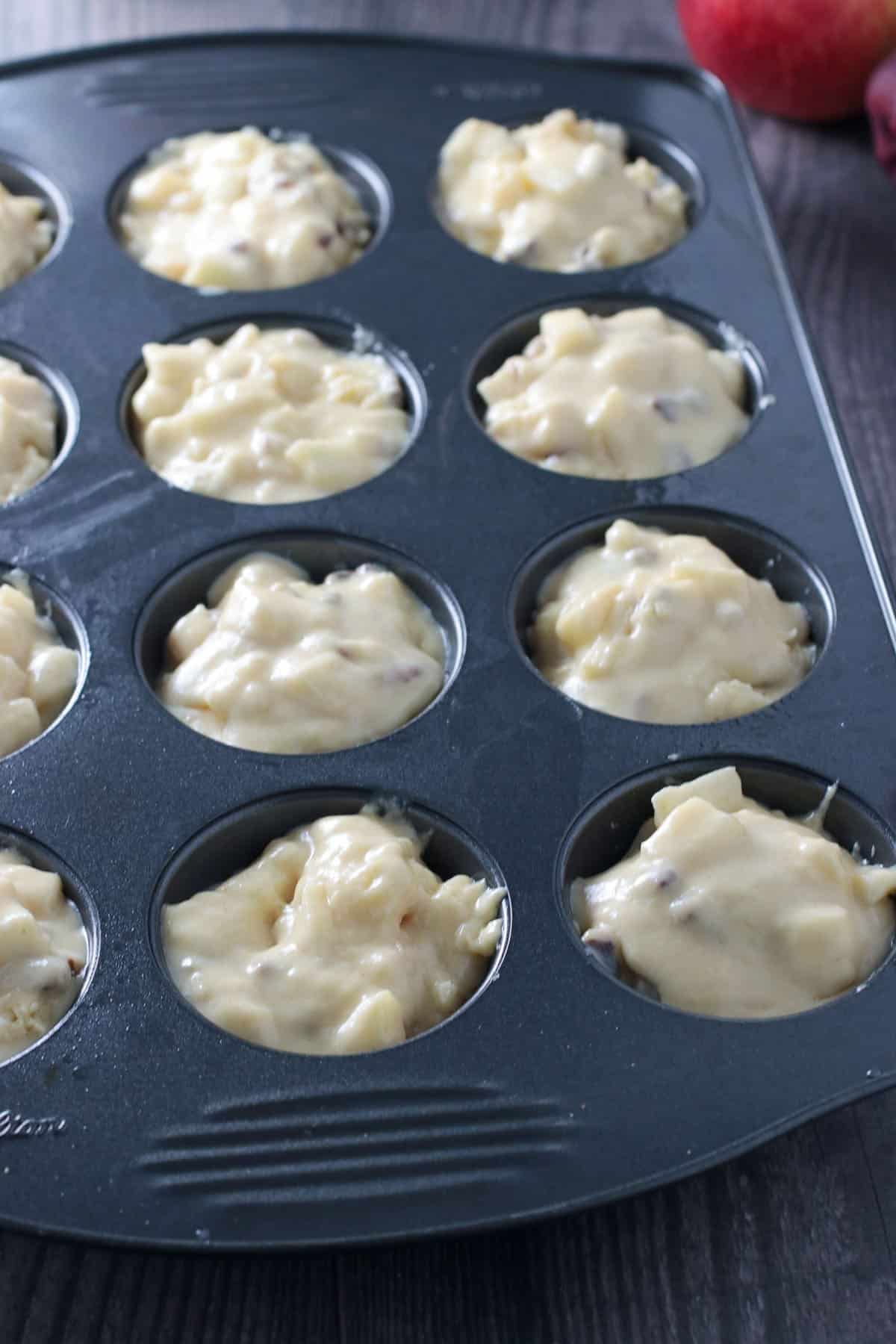 The cornbread muffin batter scooped into a muffin pan, ready for baking.